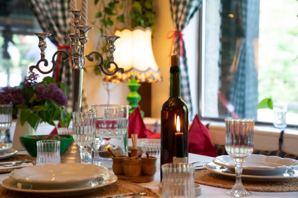 una mesa con una botella de vino y copas. en Casa cu Amintiri, en Bran