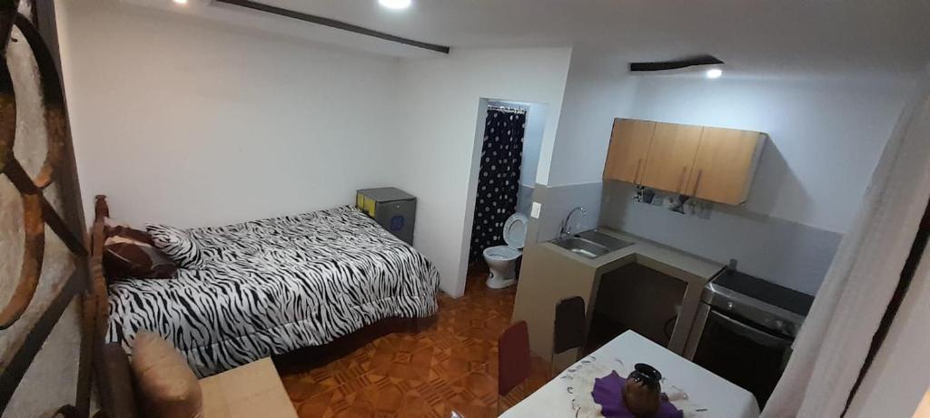 Kleines Zimmer mit einem Bett und einem Tisch in der Unterkunft Casa campestre en las faldas del Taita Imbabura 3 in Otavalo