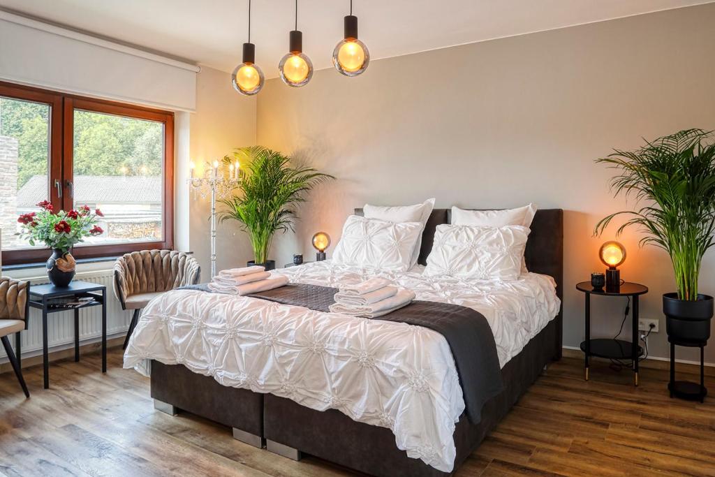 een slaapkamer met een groot bed met witte lakens bij BnB Pastel in Dilsen-Stokkem