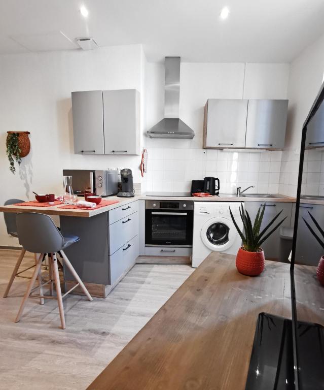 - une cuisine avec des appareils blancs et une table en bois dans l'établissement Sur les Pavés du Pont Vieux..., à Carcassonne