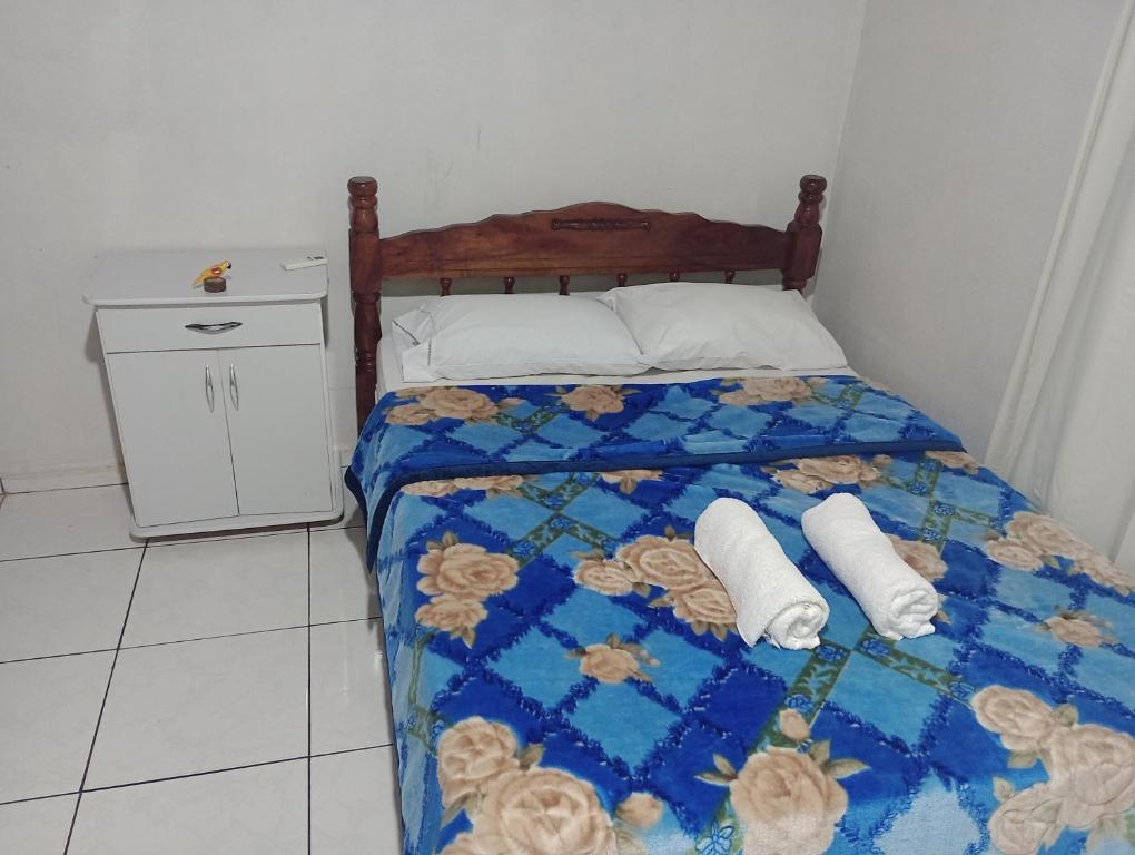 a bedroom with a bed with two towels on it at Casa Morumbi Foz do Iguaçu in Foz do Iguaçu