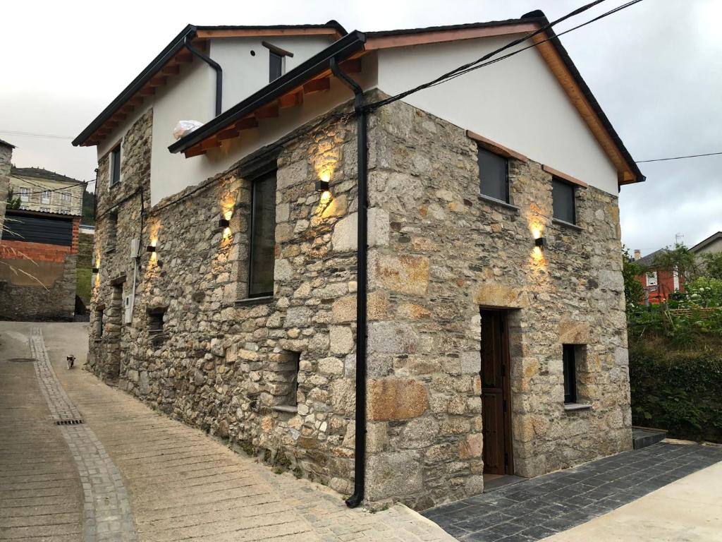 een oud stenen gebouw met een deur op een straat bij Apartamentos El Arroyo in Armal