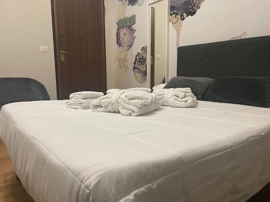 a large white bed with towels on top of it at Cucchiari Suite 7A in Modena