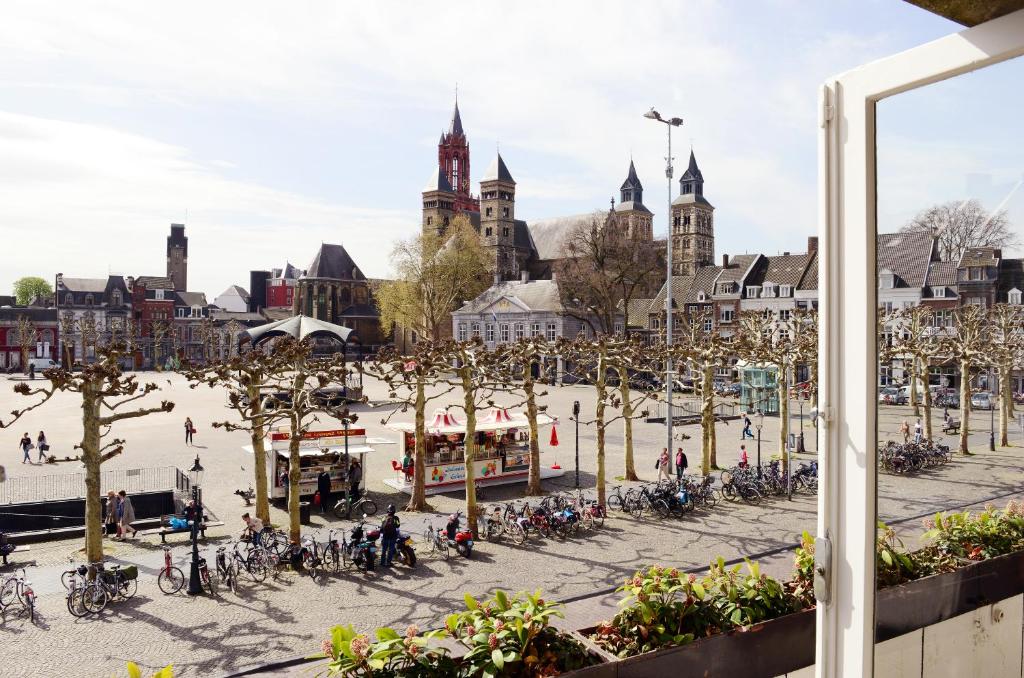 uma praça da cidade com um monte de pessoas e bicicletas em Amrâth Hotel DuCasque em Maastricht