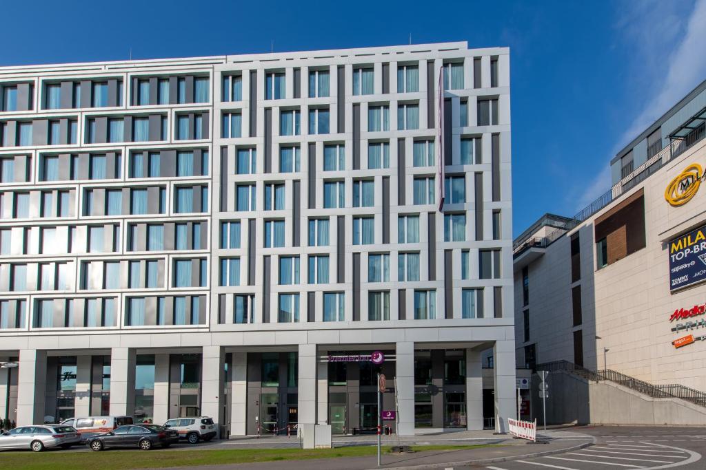 ein großes weißes Gebäude mit davor geparkt in der Unterkunft Premier Inn Stuttgart City Centre in Stuttgart