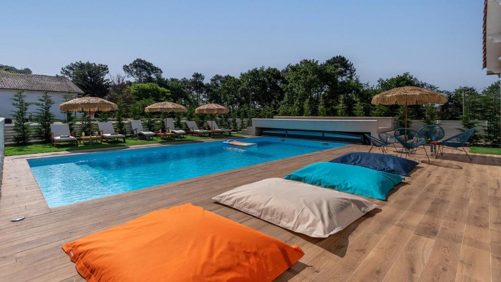 雅萊地區聖梅達爾的住宿－Villa Hakuna Matata - 4 étoiles climatisée avec piscine，木制甲板上的带两个枕头的游泳池