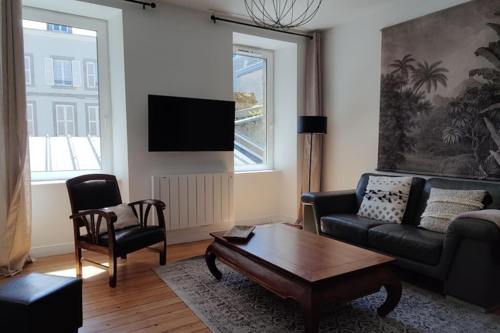 ein Wohnzimmer mit einem Sofa und einem Couchtisch in der Unterkunft Le Corsaire appartement centre ville 500 mètres des plages in Granville
