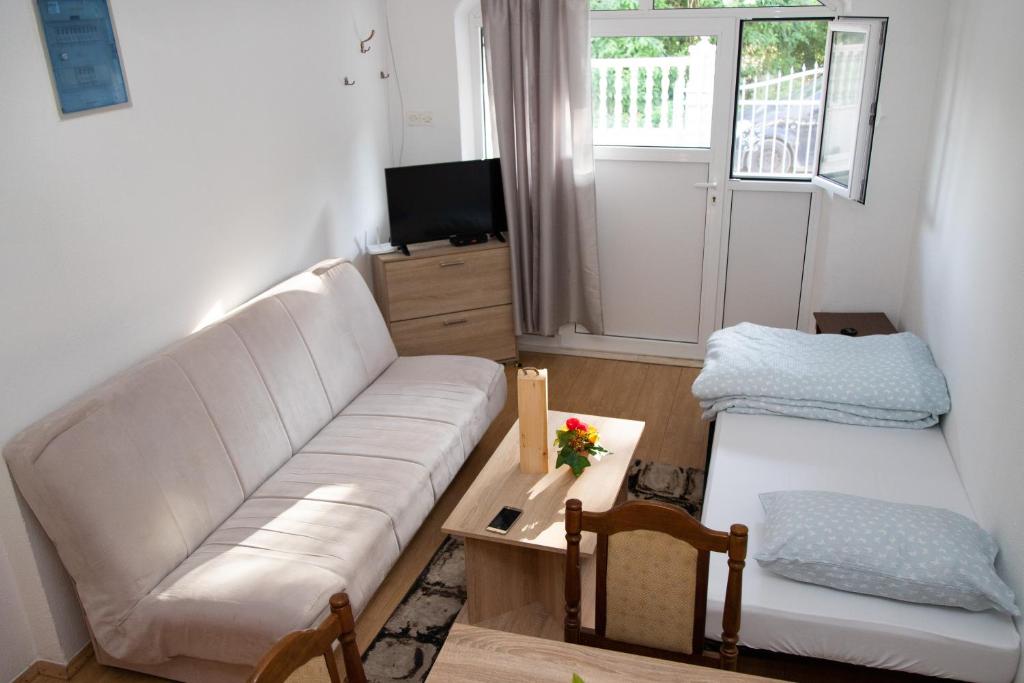 a living room with a white couch and a table at Apartman Irina Trebinje in Trebinje
