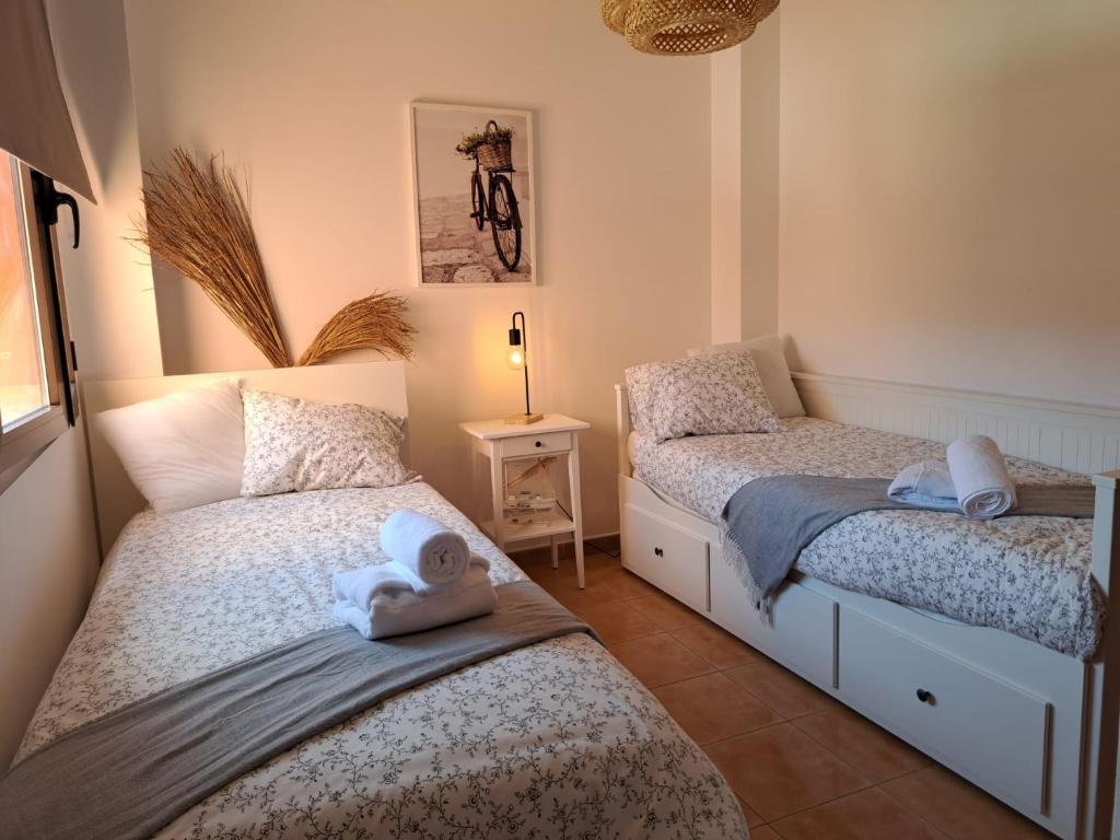een slaapkamer met 2 bedden en handdoeken bij Ático Estrella sunset in Corralejo