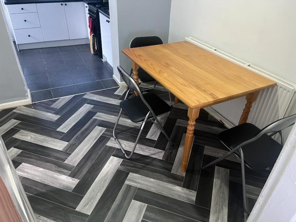 a wooden table and chairs on a tile floor at Modern property close to Aintree Hospital & Motorways in West Derby