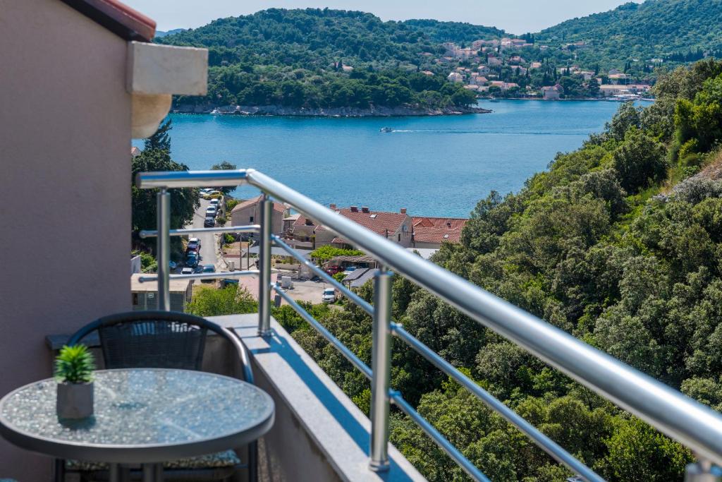 a balcony with a table and a view of a lake at Peaceful apartment near the beach - Sole in Zaton