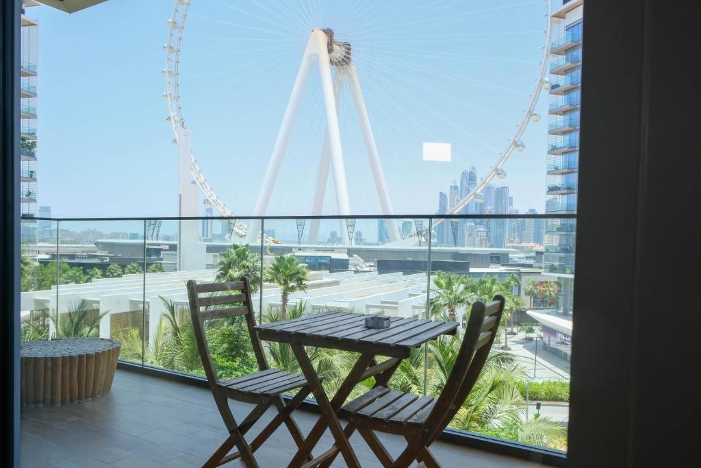 a table and chairs on a balcony with a view of a city at Mira Holiday Homes - Cozy apartment in Bluewaters in Dubai