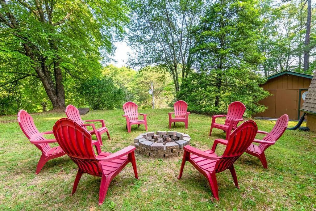 eine Gruppe roter Stühle, die um eine Feuerstelle herum sitzen in der Unterkunft Sleeps 8! Fire Pit, Games, 15 Mins from Downtown Blue Ridge in Mineral Bluff