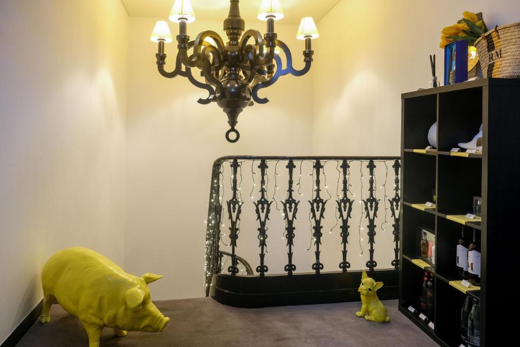 a room with a chandelier and a toy pig on the floor at RM The Experience - Small Portuguese Hotels in Setúbal