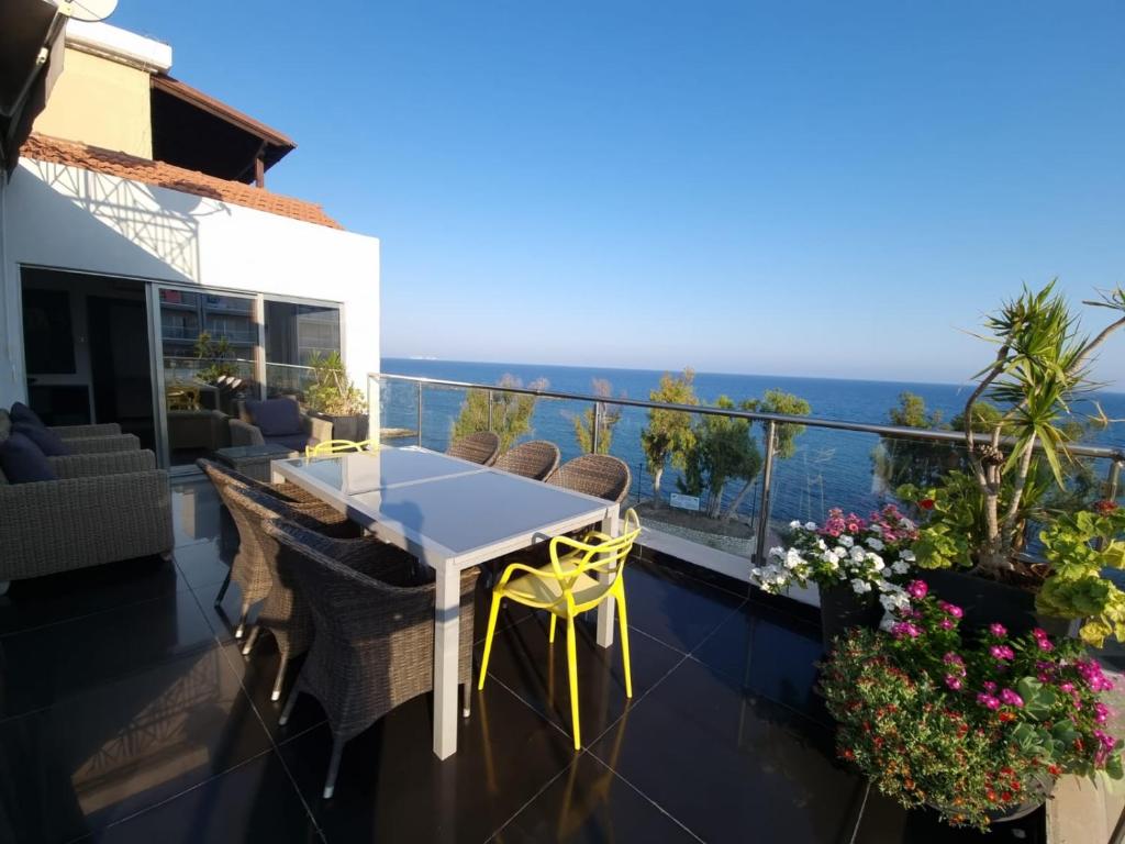 een balkon van een huis met een tafel en stoelen bij The View Beach Penthouse in Limassol