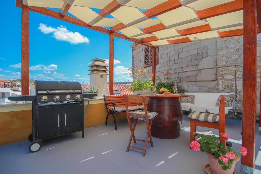 d'une terrasse avec une cuisinière et une table sur un balcon. dans l'établissement Dusica apartments, à Tribunj