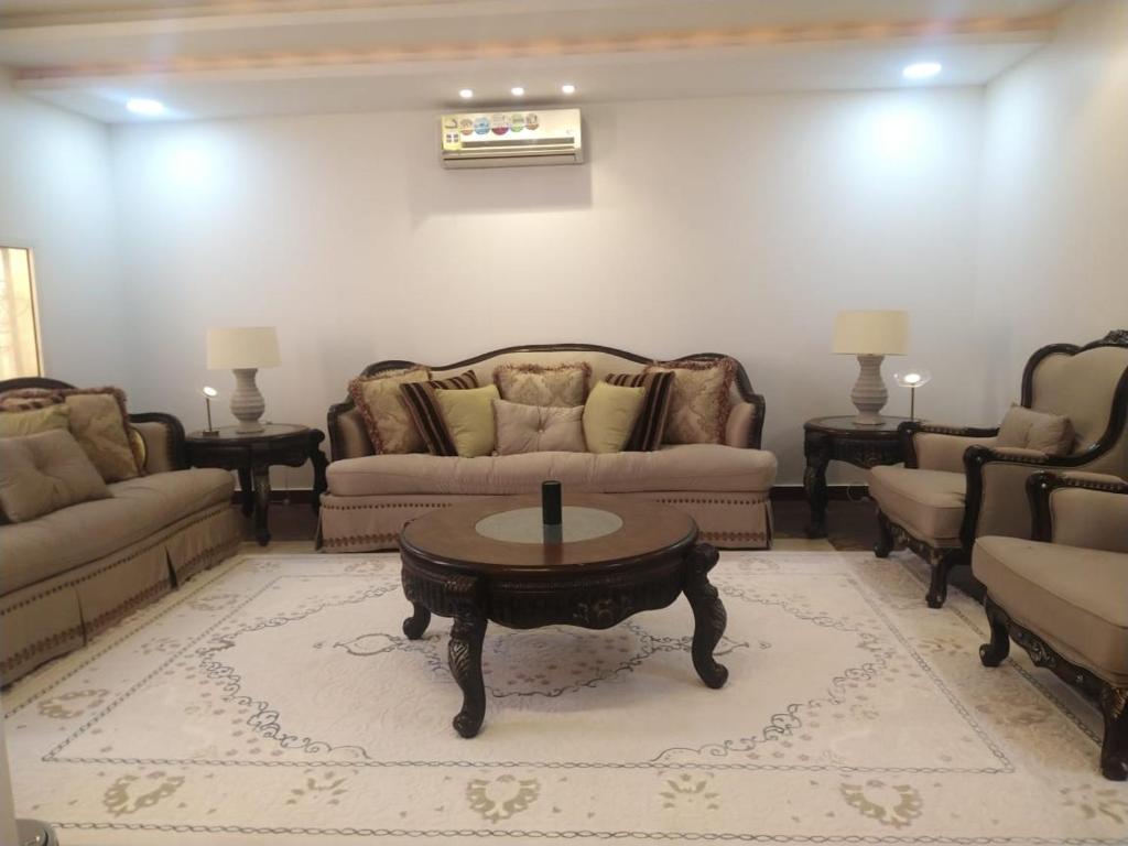 a living room with couches and a coffee table at Classy Apartment in Buraydah