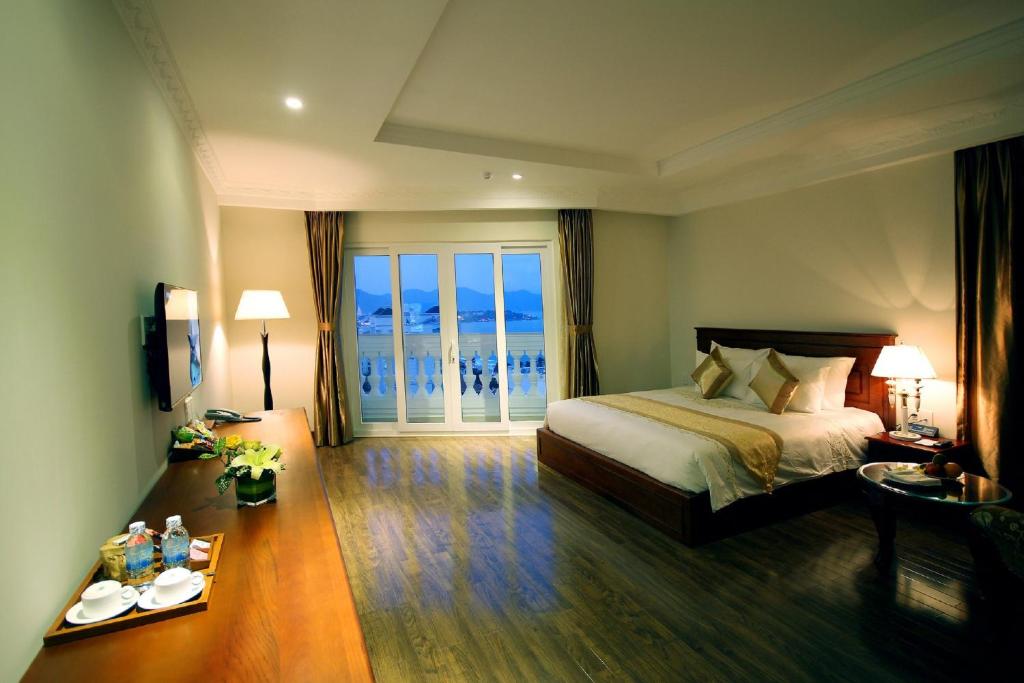 ein Hotelzimmer mit einem Bett und einem großen Fenster in der Unterkunft Nha Trang Palace Hotel in Nha Trang