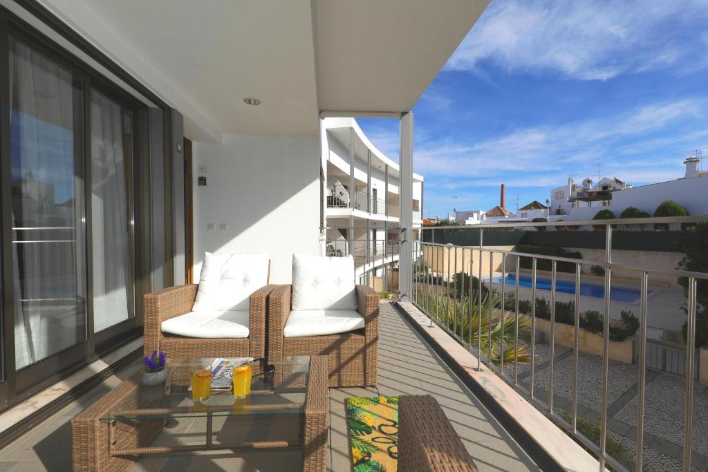 a balcony with two chairs and a table on a building at Apartment Pepita-tavira Centre, Pool & Garage in Tavira