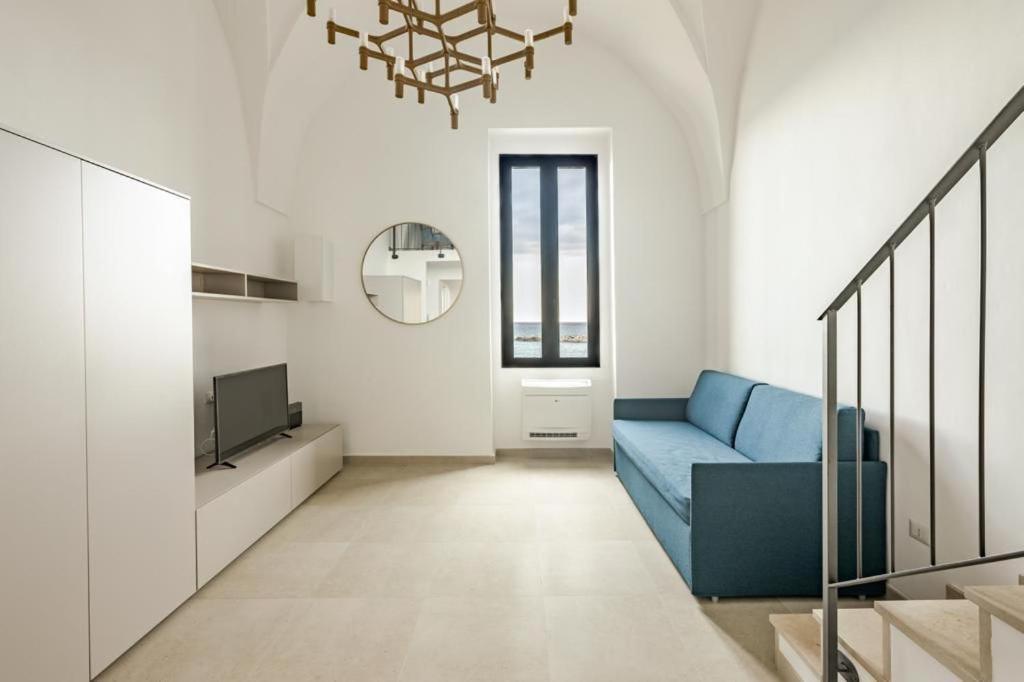 een woonkamer met een blauwe bank en een tv bij Dimora San Felice Il Fico in Gallipoli