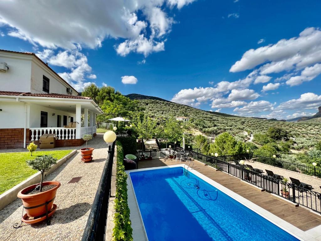 une villa avec une piscine et une montagne dans l'établissement Finca La María, à Jaén