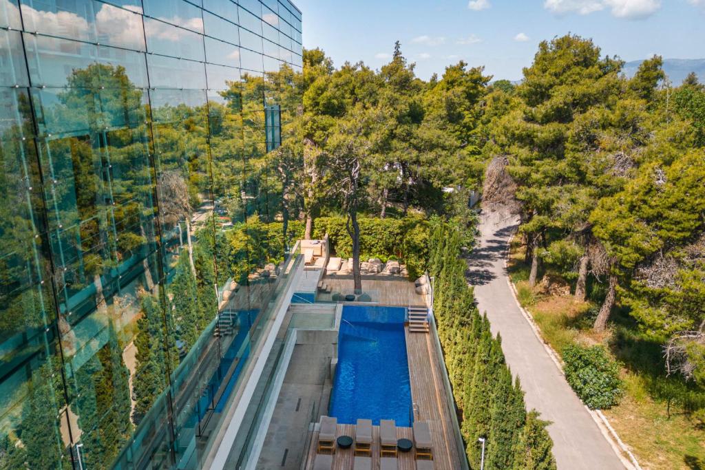 uma vista superior de uma piscina ao lado de um edifício de vidro em Life Gallery Athens em Atenas