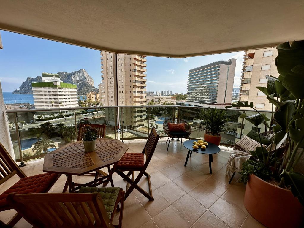 een balkon met een tafel en stoelen en uitzicht op de stad bij Esmeralda Suites in Calpe