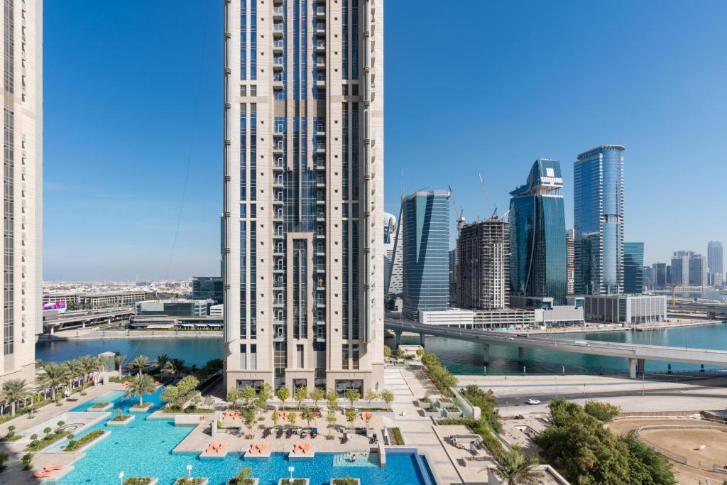 - une vue sur un bâtiment avec une piscine et une ville dans l'établissement White Sage - Amna Tower, à Dubaï