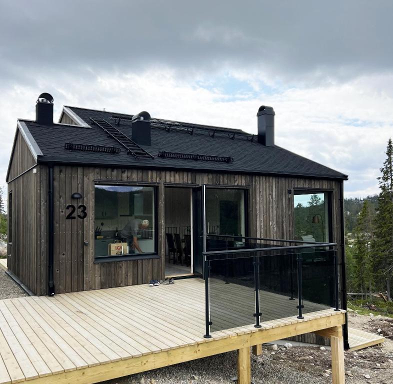 a small wooden house with a deck and windows at Lovely winter cottage in Vemdalen, close to skiing in Vemdalen