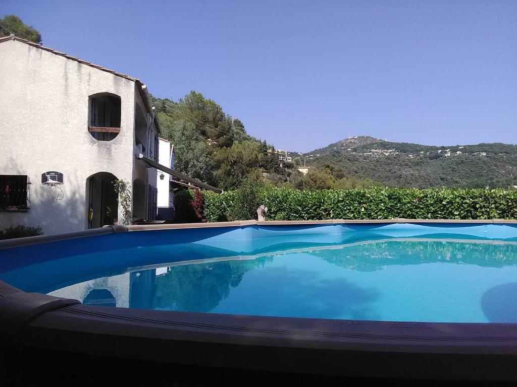 une grande piscine bleue à côté d'un immeuble dans l'établissement VILLA DE CHARME sur la Côte d'Azur, à Tourrette-Levens