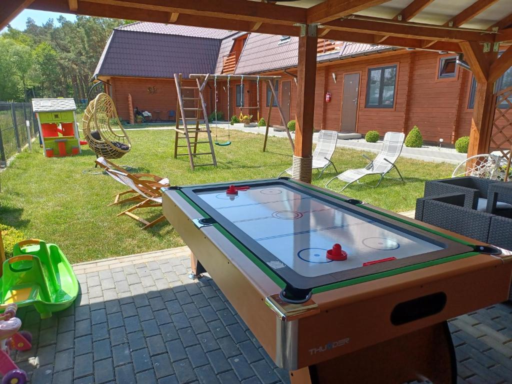 a ping pong table sitting in a backyard with at Apartamenty Majka in Wicie