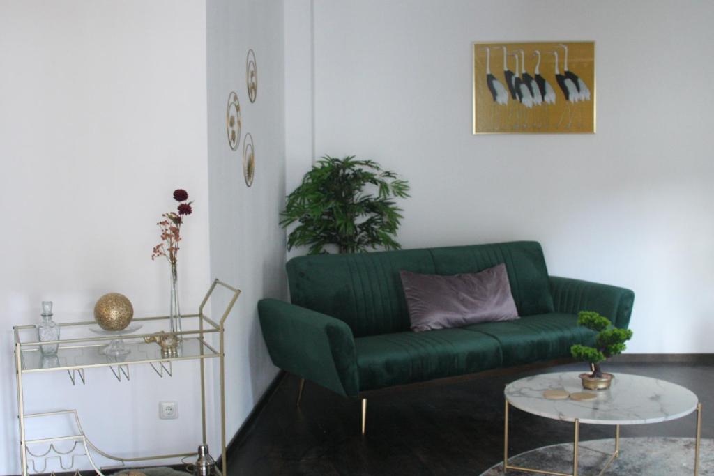 uma sala de estar com um sofá verde e uma mesa em American Ease Apartments - Hahnbach, Vilseck, Weiden em Hahnbach