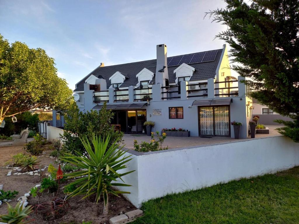 a large white house with a courtyard at Holiday Guest House Langebaan in Langebaan