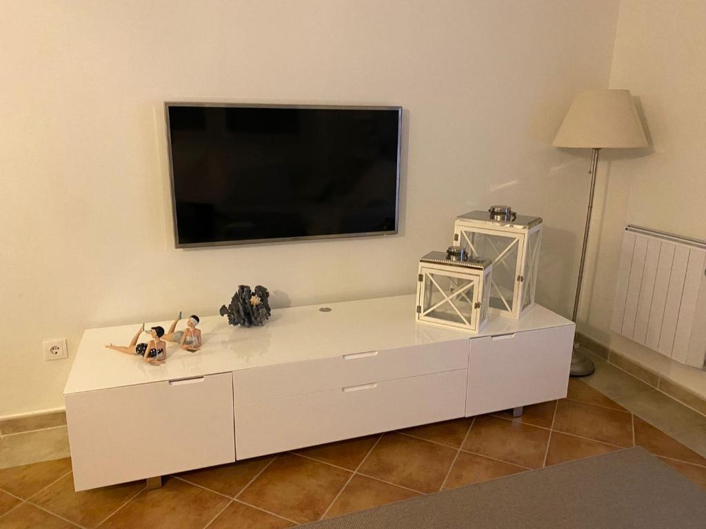 ein weißes Entertainment-Center mit einem Flachbild-TV an der Wand in der Unterkunft Apartamento premium Canela Park in Isla Canela