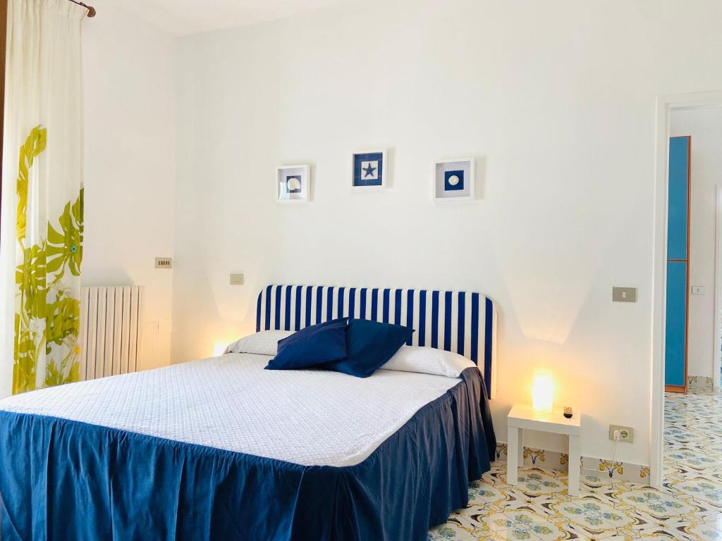 a bedroom with a bed with blue sheets and a lamp at Casa Colomba in Anacapri