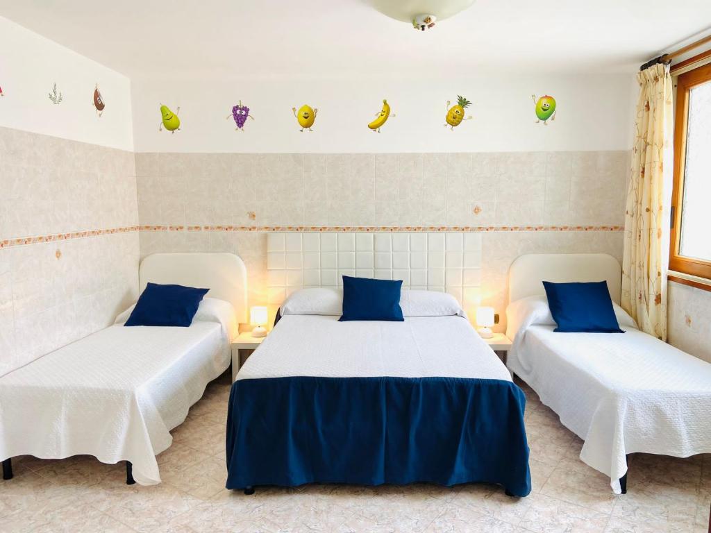 a room with two beds with blue and white sheets at Casa della Frutta in Anacapri