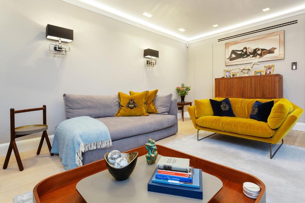 ein Wohnzimmer mit einem gelben Sofa und einem Tisch in der Unterkunft Veeve - Lavish and Luxe in London