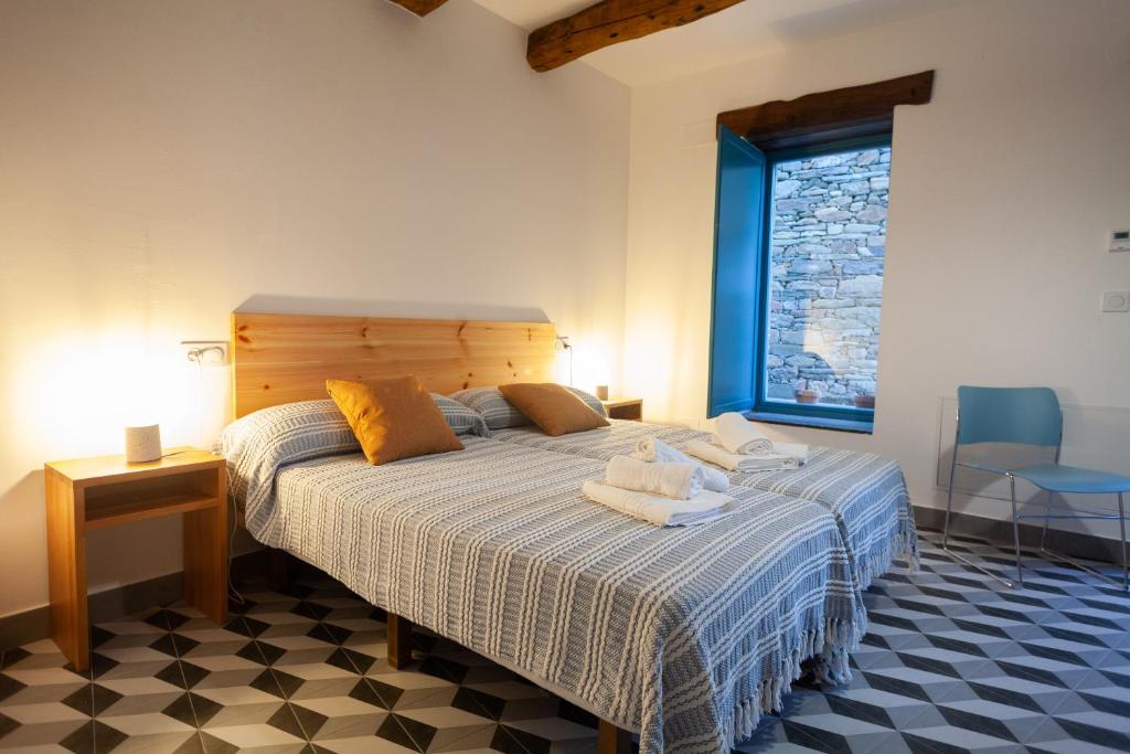 1 dormitorio con 1 cama con toallas en CASA TERRA ALMA en Laza