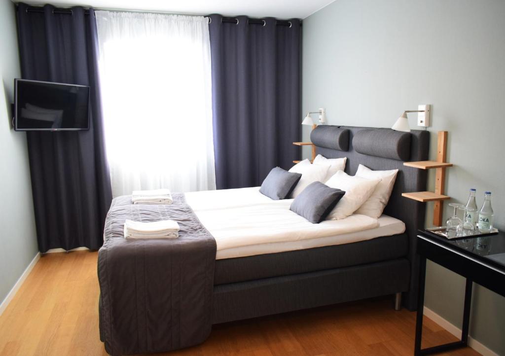 Tierp的住宿－Gästis Tierp，一间卧室配有一张大床和黑色床头板