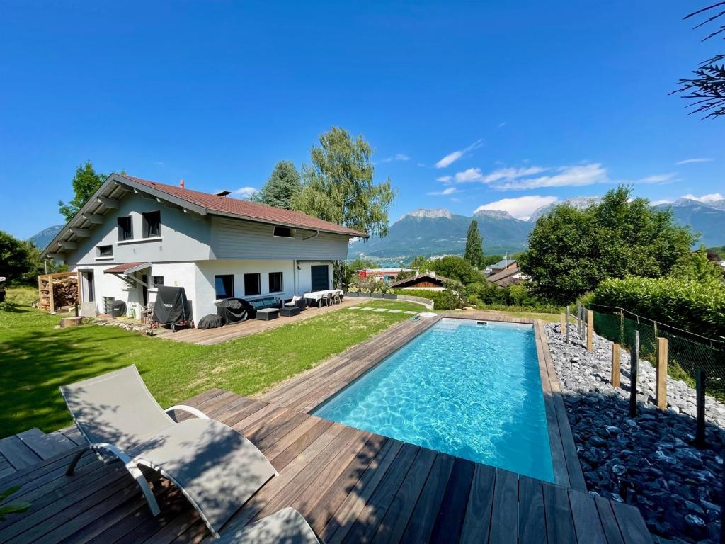une cour arrière avec une piscine et une maison dans l'établissement Superbe villa lac d'Annecy avec piscine, à Sévrier