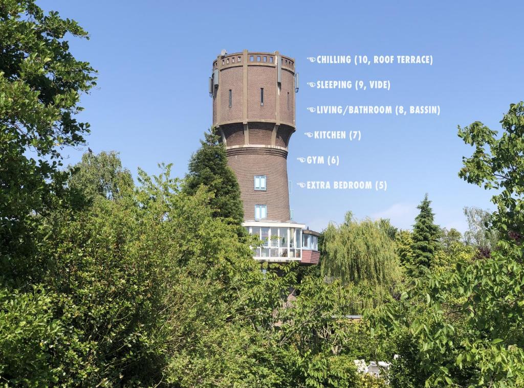 un château d'eau avec un train en haut dans l'établissement Verblijf boven in de watertoren van Strijen met dakterras, à Strijen
