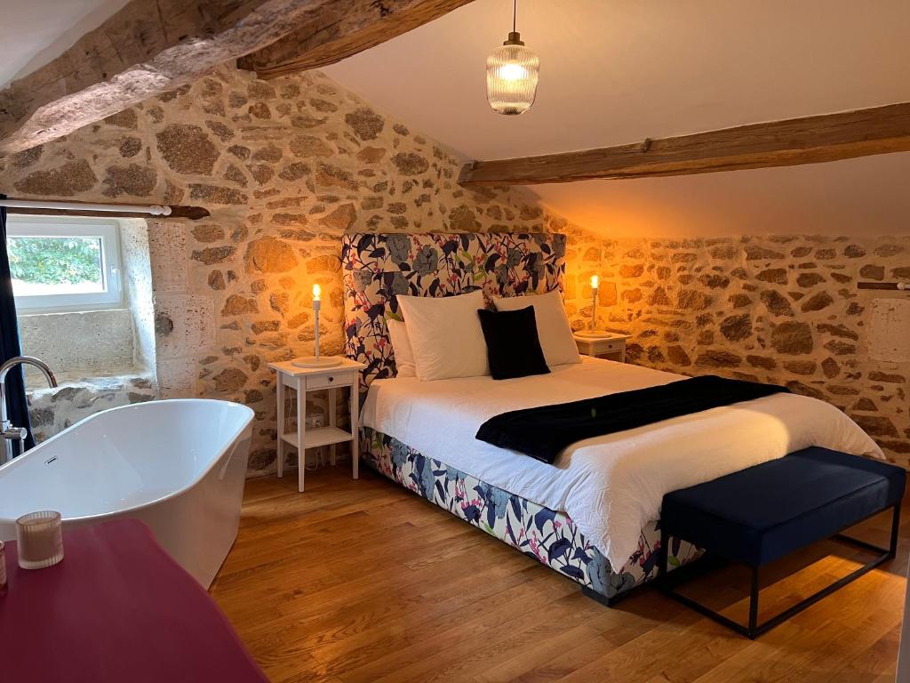 a bedroom with a bed and a bath tub at La Pêche in Piégut-Pluviers