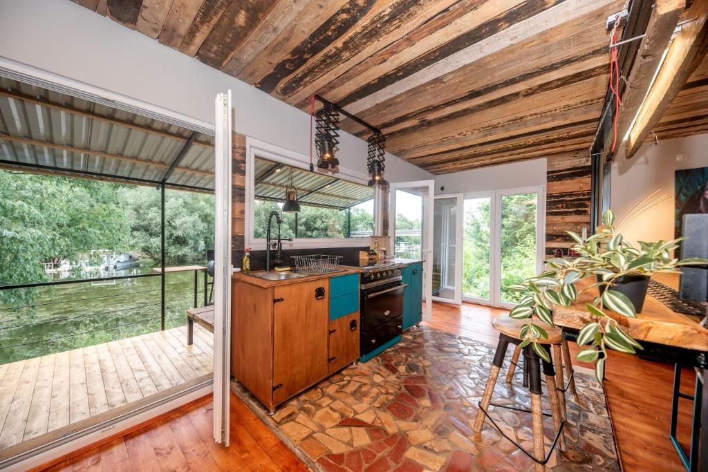 een open keuken met houten plafonds en een groot raam bij Brauhaus Danube Cottage in Petrovaradin