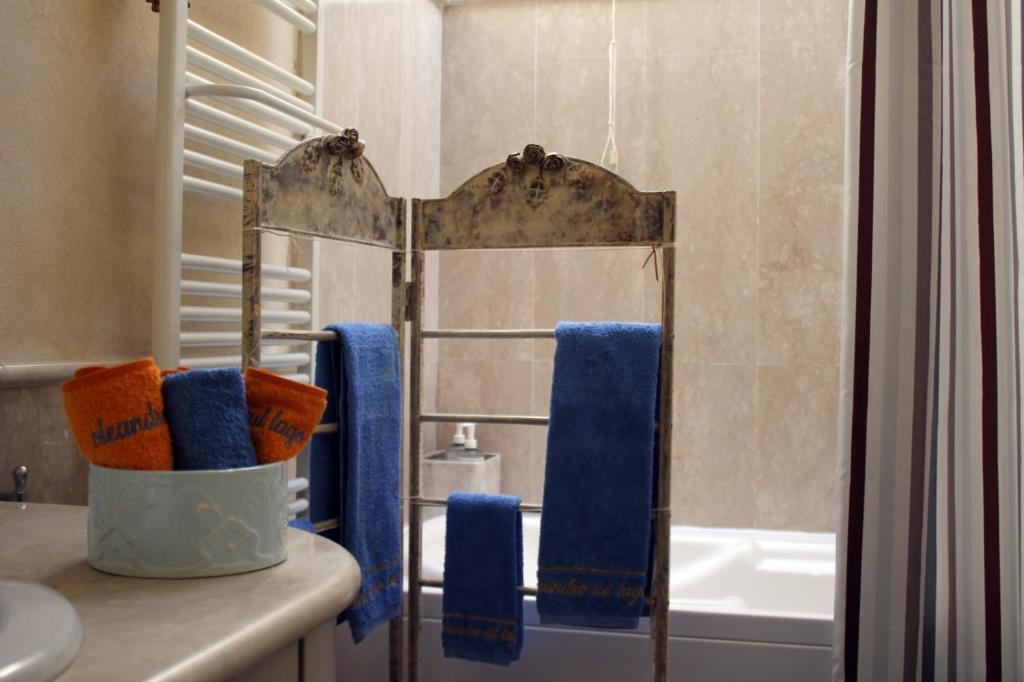 L'Oleandro sul Lago d'Iseo B&B في سولتسانو: حمام مع مرآة ومناشف زرقاء على منضدة