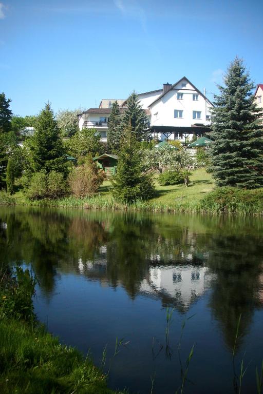 a view of a lake with a house in the background at Pensjonat Willa Edyta in Mrągowo