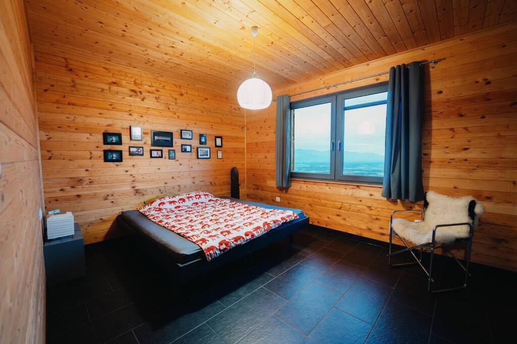 a bedroom with a bed and a window and a chair at St. Barbara Hideaway in Škofja Loka