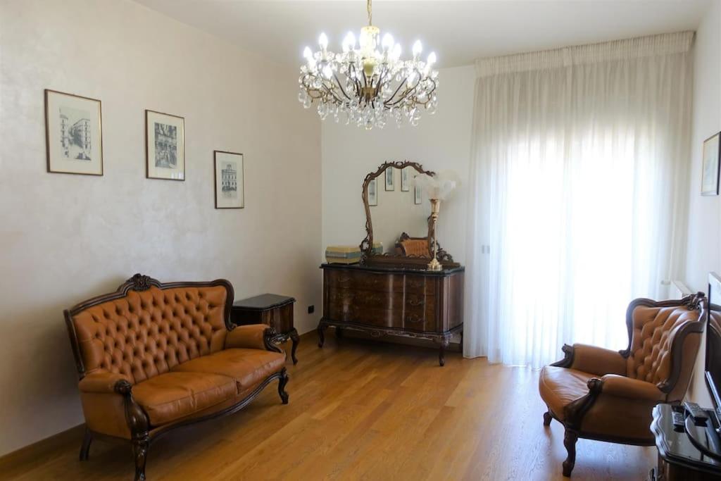 sala de estar con 2 sillas de cuero y lámpara de araña en BARI 68 - Comfort moderno & fascino antico, en Bari