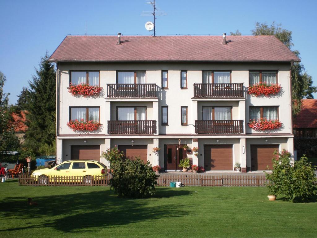 una casa con un coche amarillo aparcado delante de ella en Apartmán Orlík nad Vltavou en Orlík