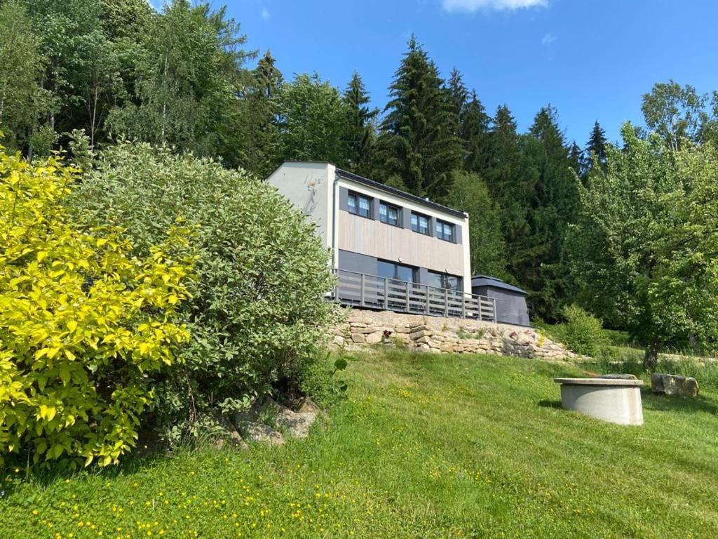 a house sitting on top of a green field at Chalupa Pod Muchovem in Velké Hamry