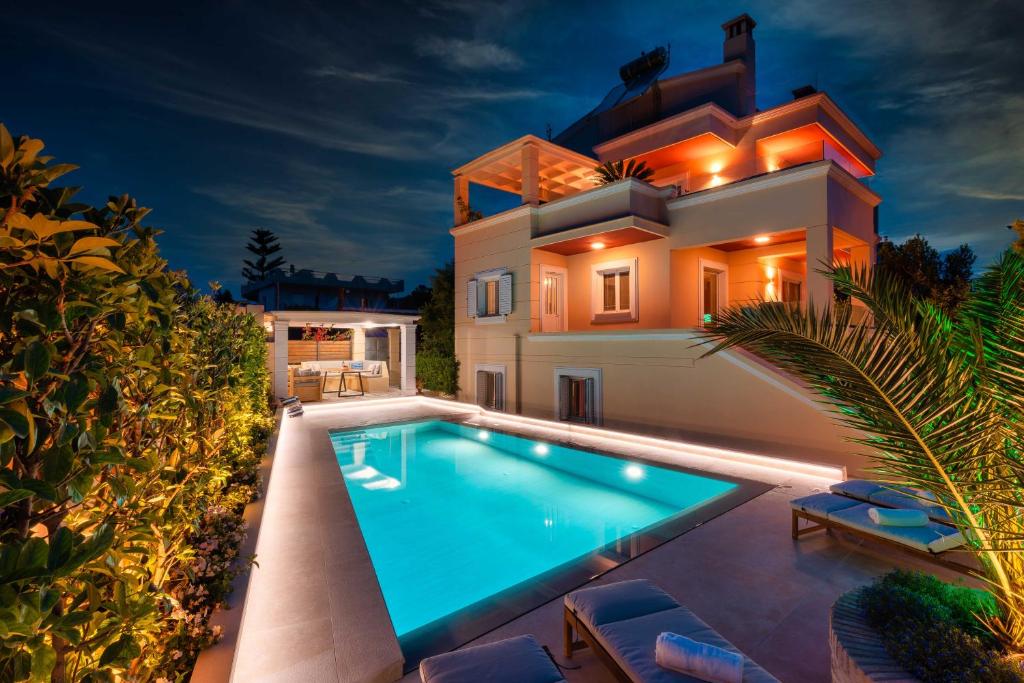 a villa with a swimming pool in front of a house at Coastline maisonette near Athens Airport and Rafina Port in Artemida
